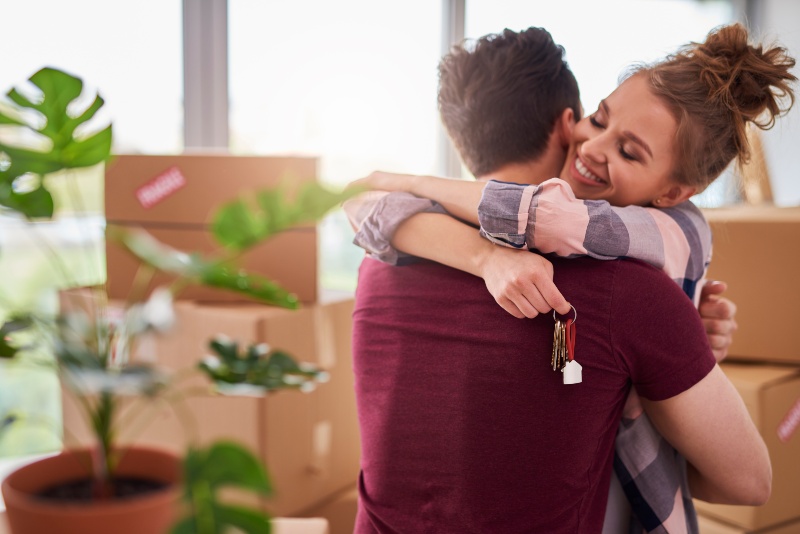 Pareja feliz con llaves de su nuevo apartamento
